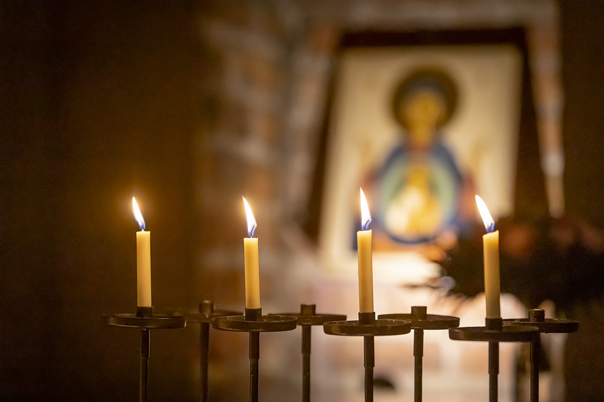 Tuomiokirkon Kristus-ikoni, jonka edessä palaa kynttilöutä.
