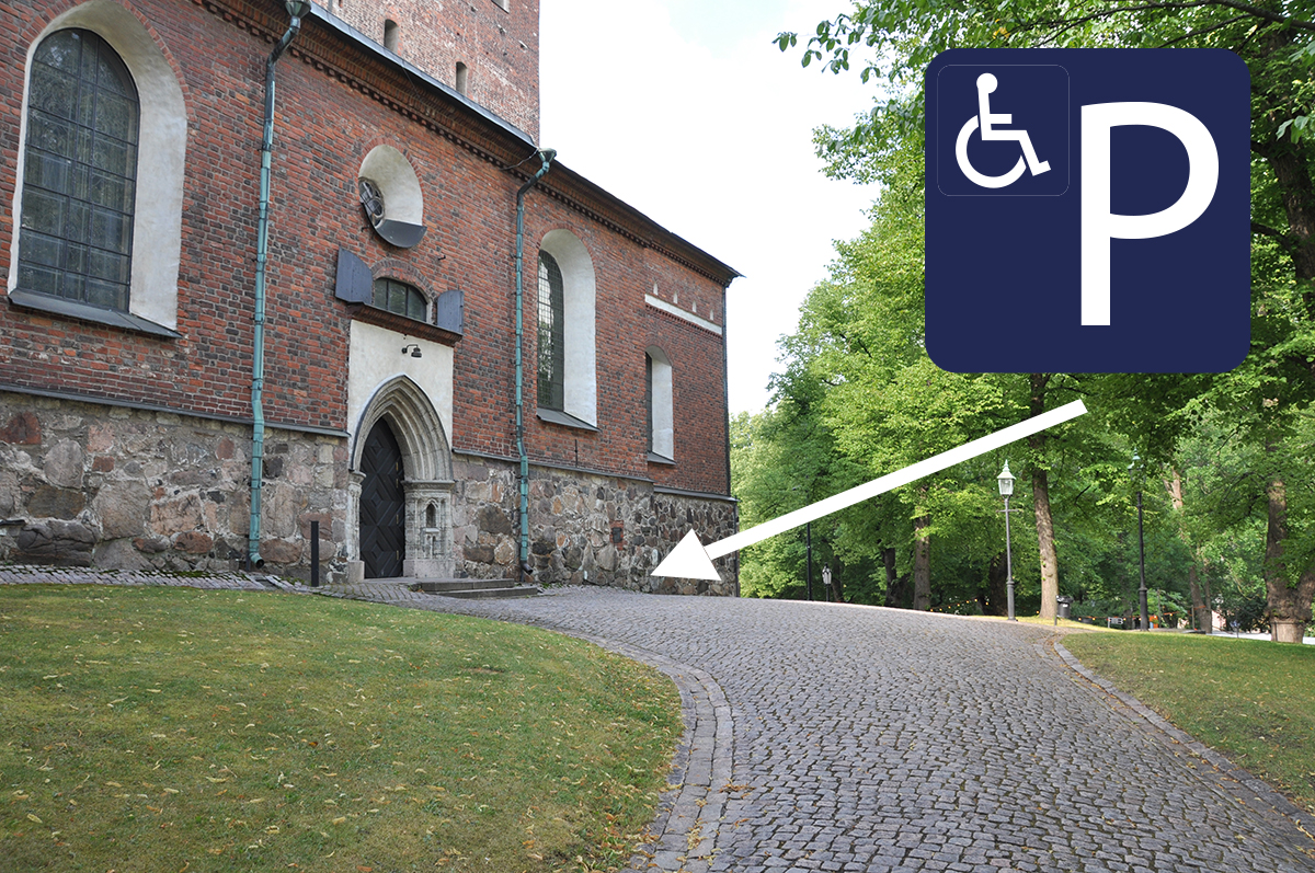 Accessible door on the side of the church, logo indicating the disabled parking spot